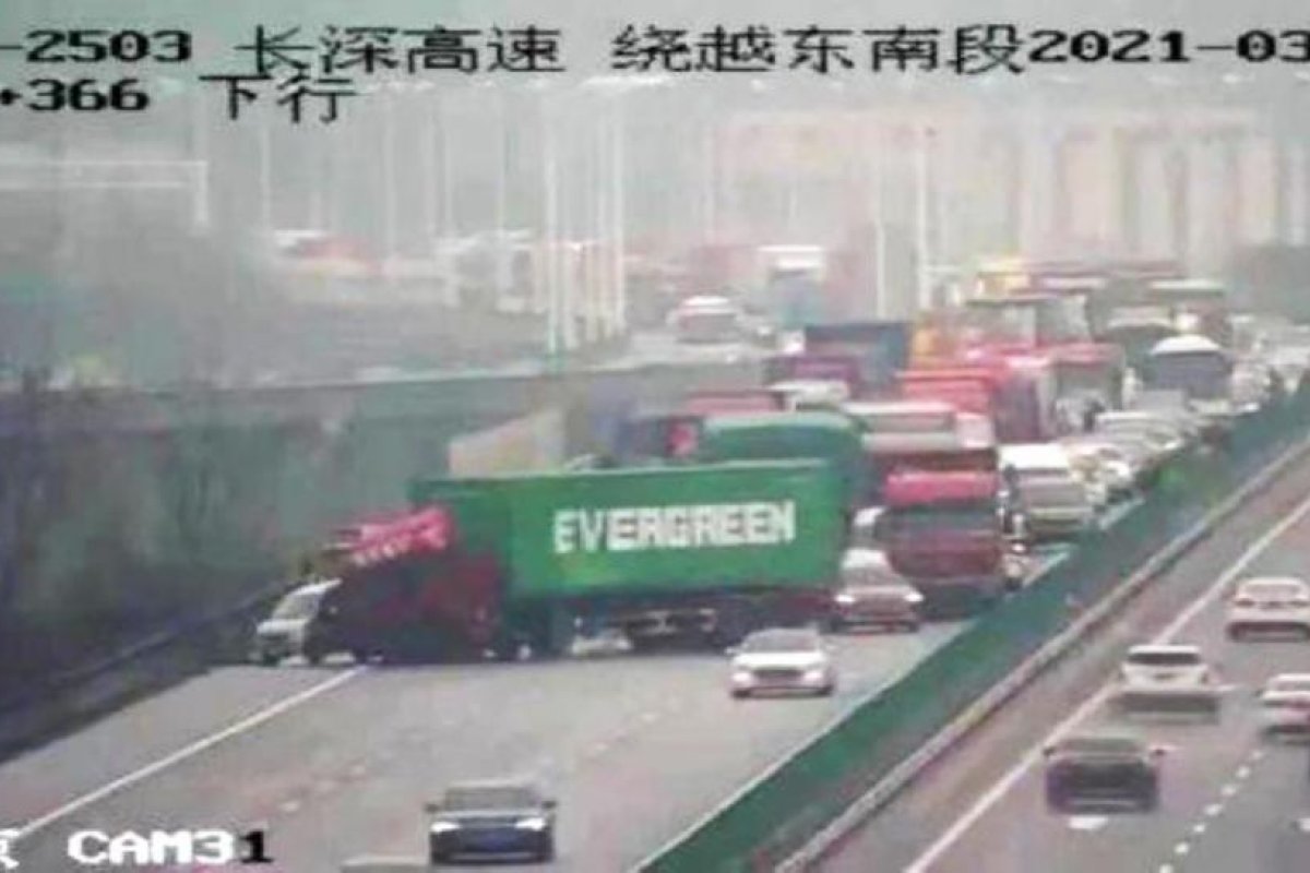 FOTO: Un camión con un contenedor con el logo de Evergreen bloquea una autopista en China, recreando el atasco del canal de Suez
